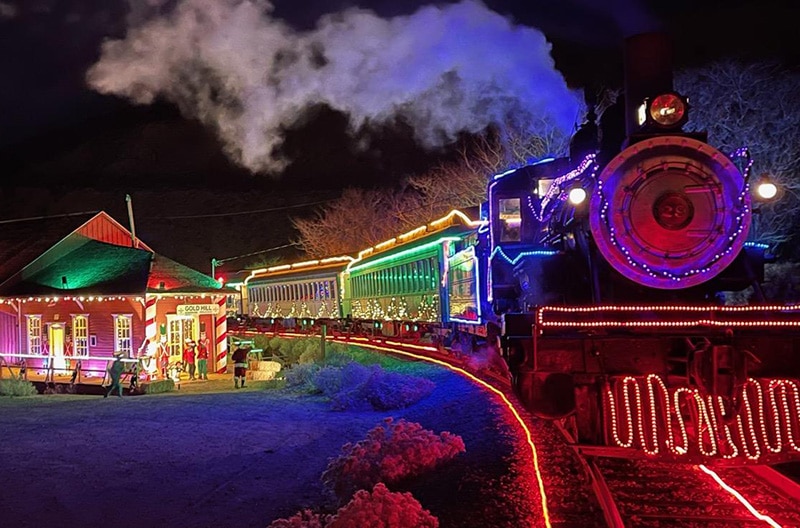 classic image of V&T #29 lit up with thousands of christmas lights, at the Gold Hill depot, also lit up for the holidays