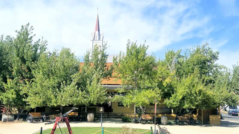view of Virginia Truckee depot in the summer with St. Mary's steeple in the background